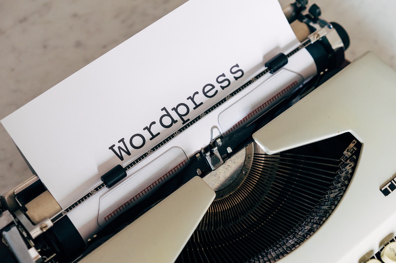 Ein Foto zeigt das Wort "Wordpress" getippt auf einem Papier, das in einer Vintage-Schreibmaschine eingespannt ist, symbolisch für die Bearbeitung und Fehlerbehebung in einer WordPress-Installation.